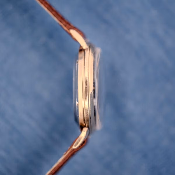 Opposite-side profile of the Cyma Cymaflex Watersport case revealing the slim mid-century proportions and gold finish.