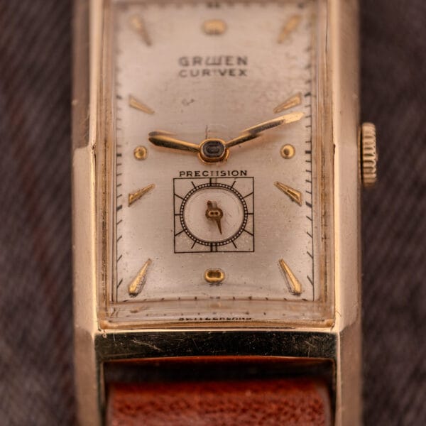 Close-up of the Gruen Curvex Precision "Pyramid Crystal" 10K GF Ref. 370-601, featuring a rectangular gold case and brown leather strap.