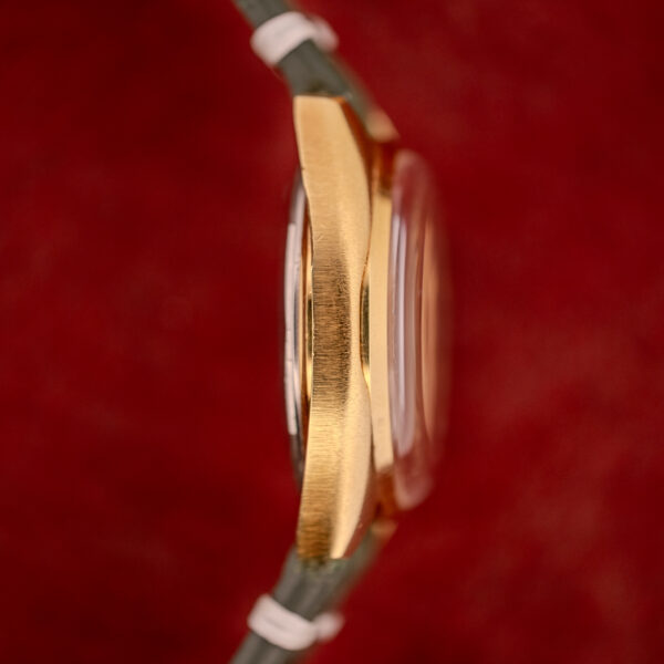 Side view of a gold Tissot Seastar Automatic Date Ref. 44660 Cal. 786-2 from the 1970s, featuring a domed crystal, shown against a red background.