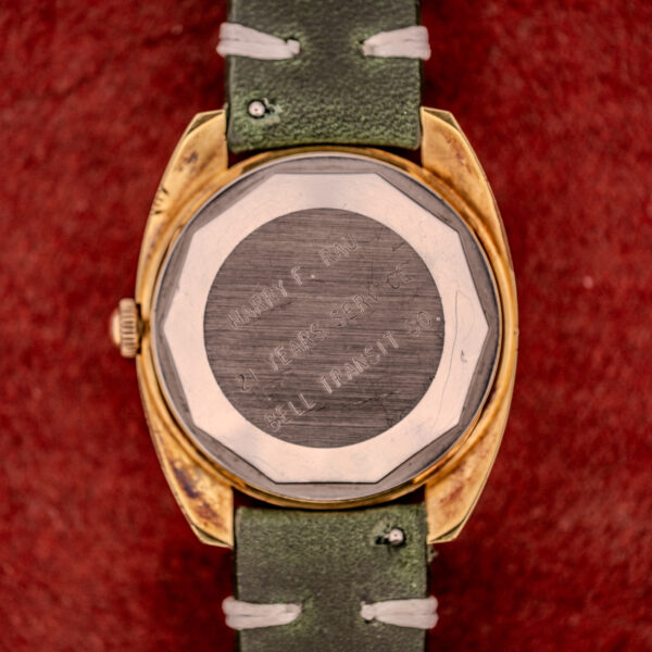Close-up of a Tissot Seastar Automatic Date Ref. 44660 Cal. 786-2 (c.1970s) wristwatch back with an engraved message, shown on a red textured surface; classic vintage style.