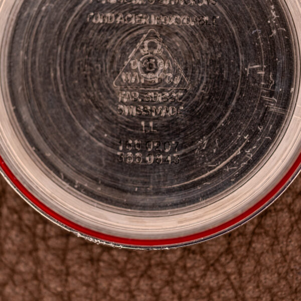 Close-up of Omega Seamaster Automatic Date "TV Case" Ref. 166.0207 Cal. 1010 case back, featuring engraved serial numbers and "Swiss Made" text on its polished surface, highlighting the precision of this iconic timepiece.