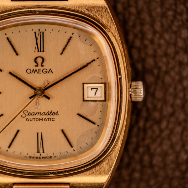 Close-up of an Omega Seamaster Automatic Date "TV Case" Ref. 166.0207 Cal. 1010, featuring a gold case, detailed dial, hands, and the date window at 3 o’clock.