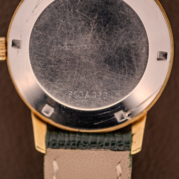 Close-up of the scratched back case of a Zenith Automatic Date Cal. 2542 25 Jewels Sunburst Dial wristwatch, engraved with numbers 810A983.