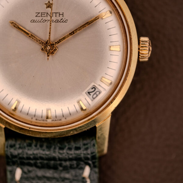 Close-up of a Zenith Automatic Date Cal. 2542 25 Jewels watch with a sunburst dial showing the date as 26, paired with a black leather strap.