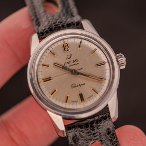 A close-up of an Enicar Sherpa Seapearl 600 Super Compressor Ref. 140/013 Cal. AR 1140 wristwatch with a black leather strap, gold hour markers, and the iconic Super Compressor case.