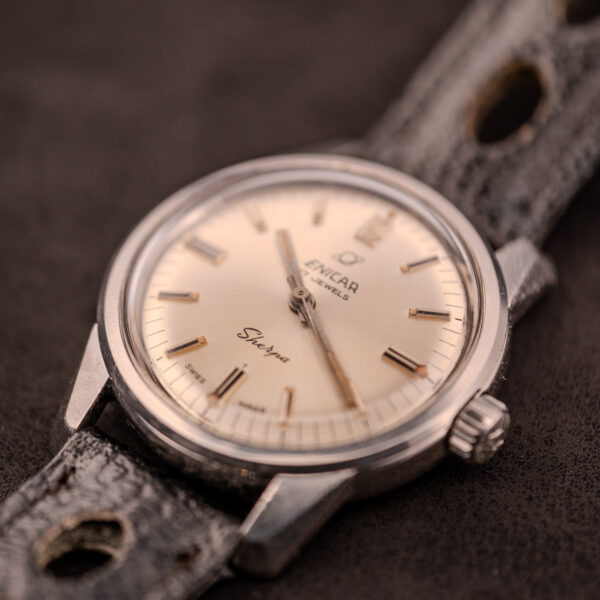 Close-up of an Enicar Sherpa Seapearl 600 Super Compressor Ref. 140/013 Cal. AR 1140 wristwatch, featuring a cream dial and a worn black leather strap.