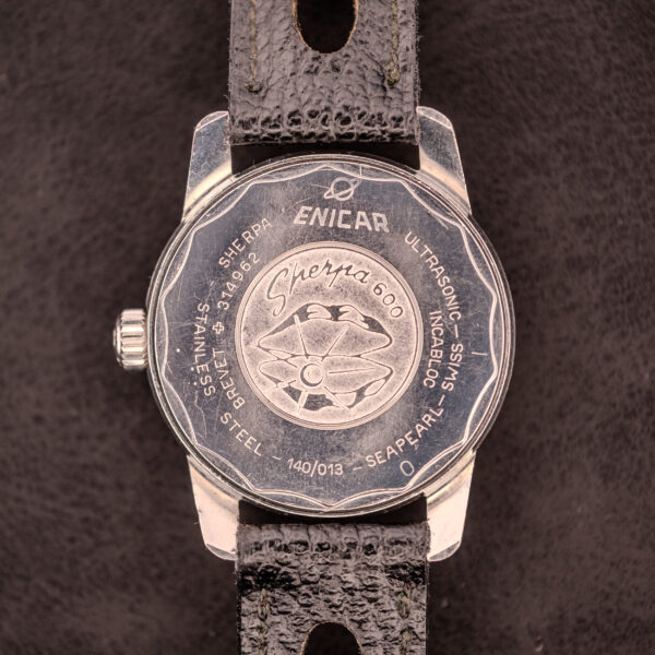 Back of an Enicar Sherpa Seapearl 600 Super Compressor Ref. 140/013 Cal. AR 1140, featuring its signature Super Compressor engravings and a black leather strap, elegantly presented on a dark surface.
