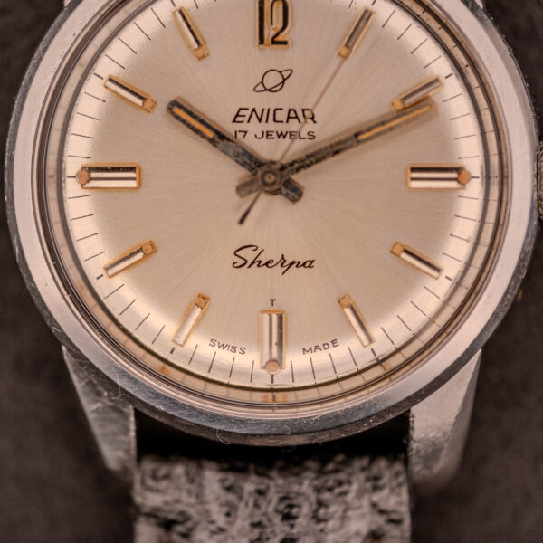 Close-up of an Enicar Sherpa Seapearl 600 Super Compressor Ref. 140/013 wristwatch featuring a beige dial, Cal. AR 1140 movement, and black leather strap.