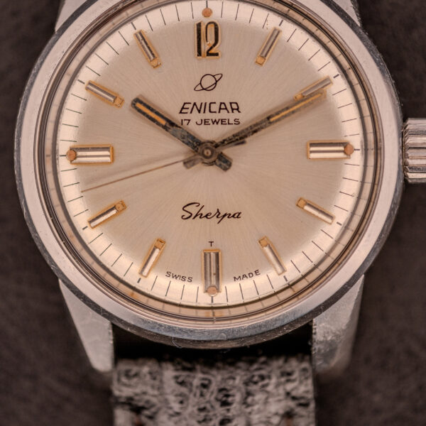 Close-up of an Enicar Sherpa Seapearl 600 Super Compressor Ref. 140/013 wristwatch featuring a silver face, black textured strap, and Cal. AR 1140 movement in a Super Compressor case.