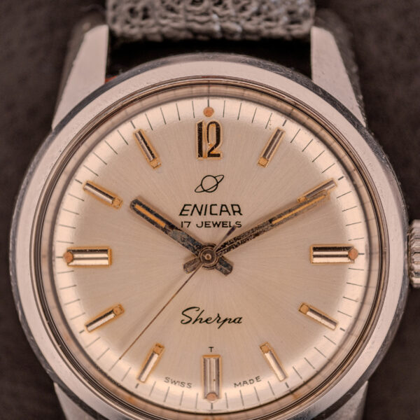 Close-up of the Enicar Sherpa Seapearl 600 Super Compressor Ref. 140/013, featuring a silver dial, gold hour markers, and Cal. AR 1140 movement in the iconic Super Compressor case.