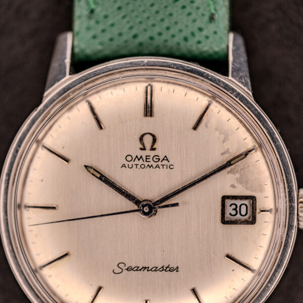 Close-up of an Omega Seamaster Automatic Date Ref. 166.037 Cal. 565 c.1968 watch with a green strap, date set to 30.