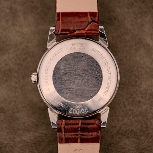 The back of a Zodiac Glorious Automatic "Faceted Bezel" Ref. 696 Cal. 1624 wristwatch with brown leather strap features engraved text on the metal case and reveals its signature faceted bezel design.