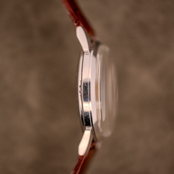 Side view of the Zodiac Glorious Automatic "Faceted Bezel" Ref. 696 Cal. 1624, showcasing its faceted bezel and brown leather strap, set against a blurred brown background.