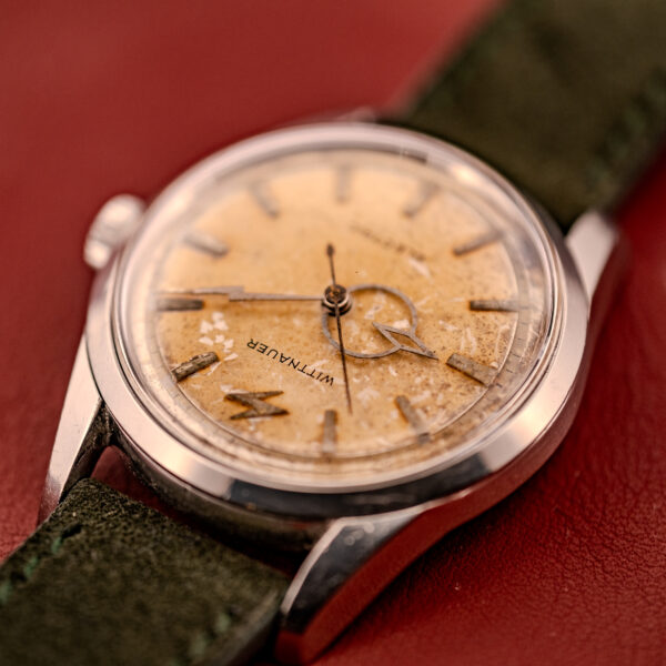 Close-up of a vintage Wittnauer Electro-Chron "Lightning Bolt" Tropic Dial Ref. 6150 wristwatch, featuring its worn Tropic Dial and a green leather strap.