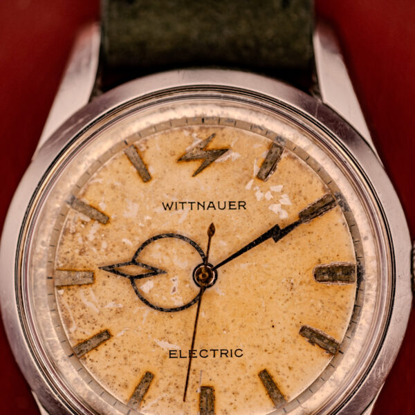Close-up of a vintage Wittnauer Electro-Chron "Lightning Bolt" Tropic Dial Ref. 6150 wristwatch showcasing its worn, yellowed tropic dial and bold black hands.