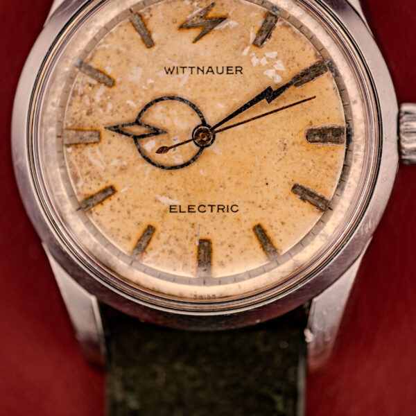 Close-up of a vintage Wittnauer Electro-Chron "Lightning Bolt" Tropic Dial Ref. 6150 wristwatch, featuring its signature lightning bolt hands and aged yellowed dial.
