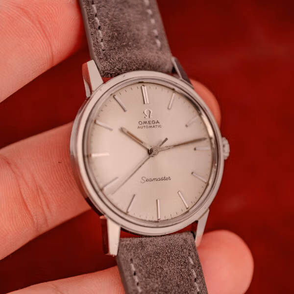 Wrist-presentation angle of Omega Seamaster ref. 165.002 held in hand showing the slim case and clean no-date dial layout
