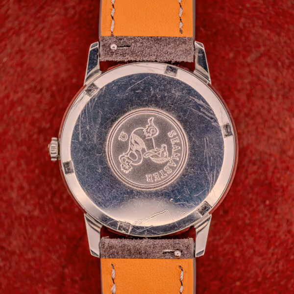 Outer caseback of Omega Seamaster 165.002 showing embossed Seamaster hippocampus medallion on polished stainless steel