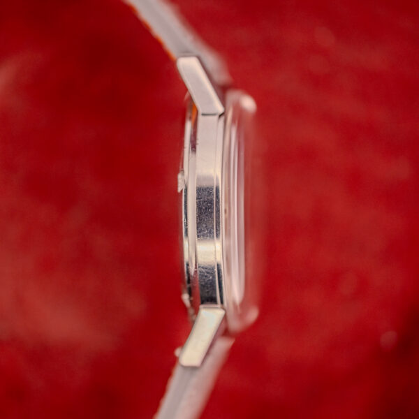 Side view of the Omega Seamaster Automatic Ref. 165.002 Cal. 552, set against a red textured background.
