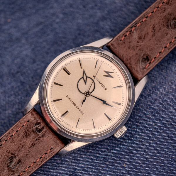 A Wittnauer Electro-Chron "Lightning Bolt" Ref. 6150/2 Cal. 11EW c.1962 watch with a brown leather strap shown on denim fabric.