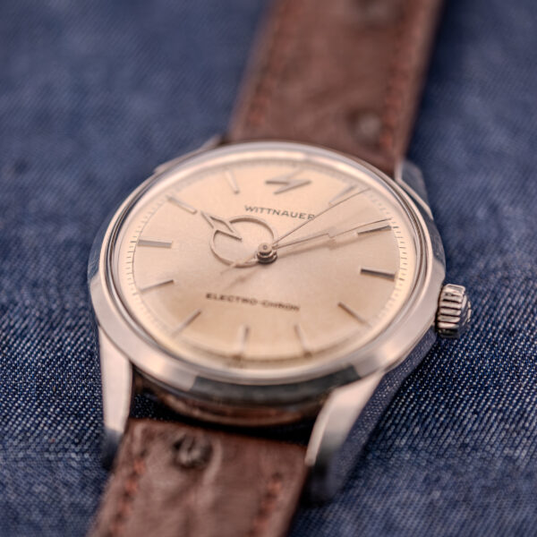 A Wittnauer Electro-Chron "Lightning Bolt" Ref. 6150/2 Cal. 11EW c.1962 with a brown leather strap is elegantly displayed on blue denim fabric.