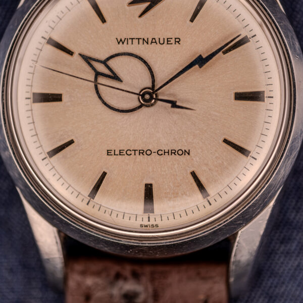 Close-up of a Wittnauer Electro-Chron "Lightning Bolt" Ref. 6150/2 Cal. 11EW c.1962 watch face, featuring black markers, distinctive Lightning Bolt seconds hand, and a brown leather strap.