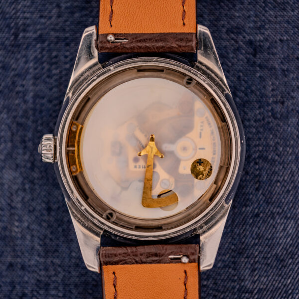 The Wittnauer Electro-Chron "Lightning Bolt" Ref. 6150/2 Cal. 11EW c.1962 features electric elegance, with a distinctive seconds hand, resting on blue fabric—a classic piece showcasing mid-century innovation and style.