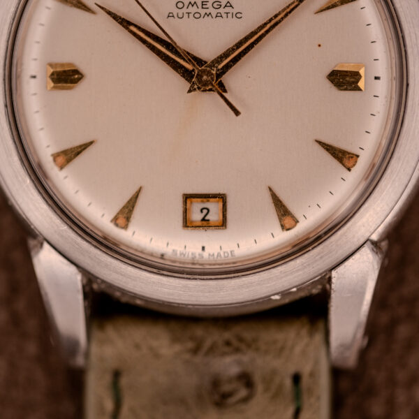 Close-up of an Omega Transitional Calendar Bumper Automatic Ref. 2438-2 Cal. 353 c.1951 watch face with gold hour markers, showing the date and its Cal. 353 bumper automatic movement.