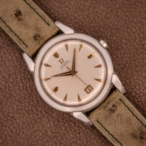 The Omega Transitional Calendar Bumper Automatic Ref. 2438-2 Cal. 353 (c.1951) features a cream dial with date at 3 o’clock, Cal. 353 automatic movement, and a tan leather strap.