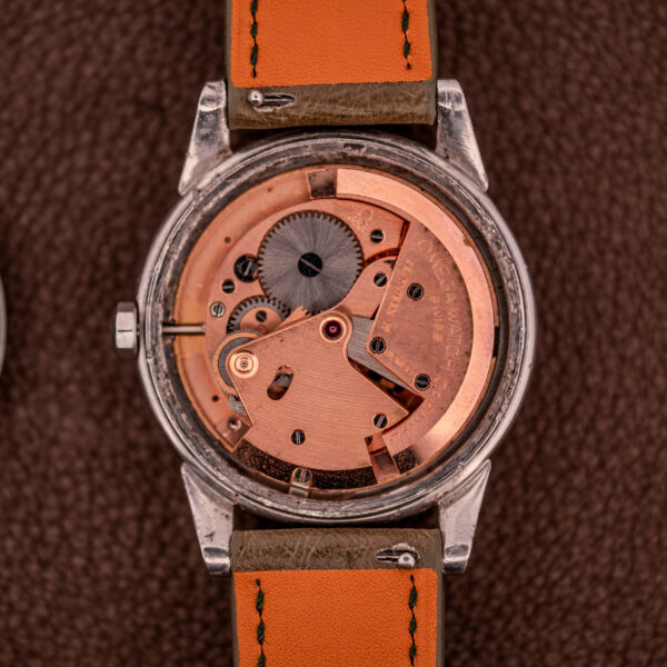 A close-up of the Omega Transitional Calendar Bumper Automatic Ref. 2438-2 Cal. 353 c.1951, showing its exposed mechanical movement, visible gears, and a brown leather strap.