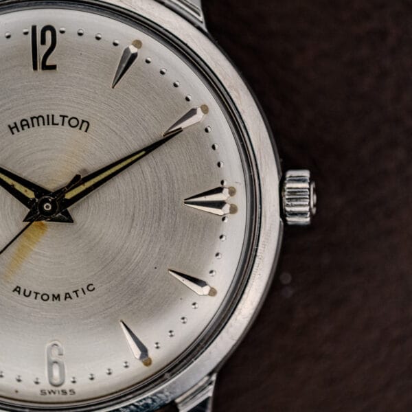Close-up of the Hamilton Automatic Silver Sunburst Micro-Rotor Cal. 666 wristwatch with a silver sunburst dial, displaying the time 10:10 against a dark background.