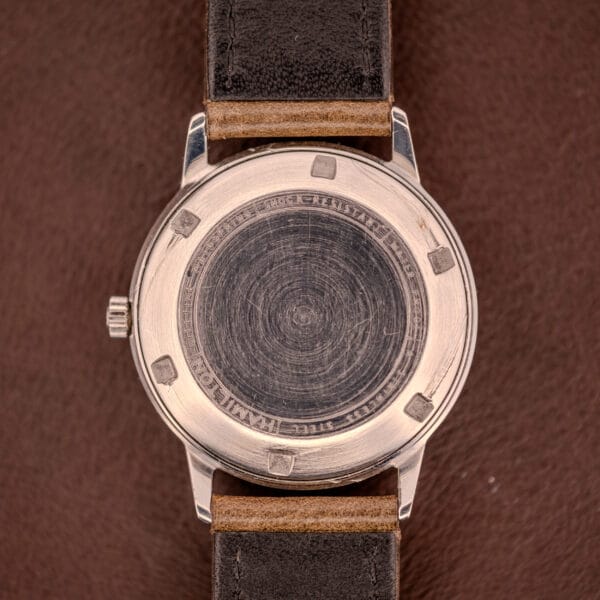 The back of a Hamilton Automatic Silver Sunburst Micro-Rotor Cal. 666 wristwatch with a leather strap, featuring engraved text along the edge and offering a glimpse of the refined Micro-Rotor movement inside.