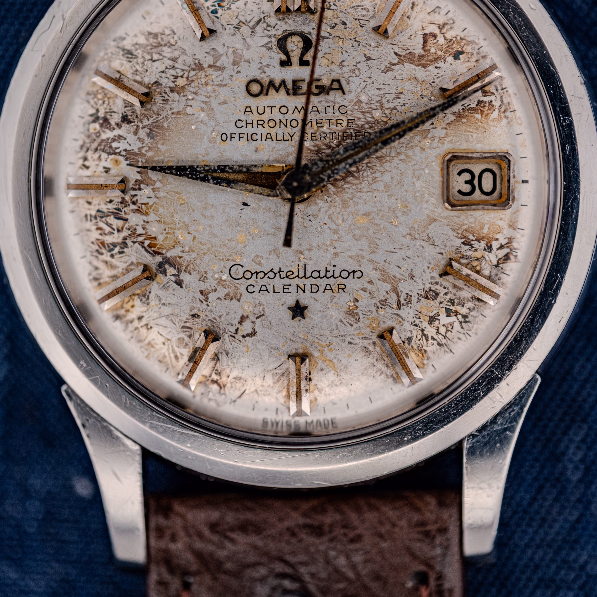 Close-up of an Omega Constellation Calendar Chronometer Ref. 2943 with a tropic "De Luxe" Dial, showing its worn texture and visible date window.