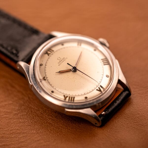 Omega Pre-Seamaster 2584-1 dial angled with the OTTUHR black ostrich strap curling under the lug