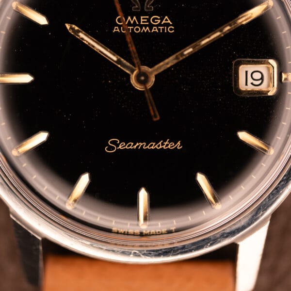 Omega Seamaster 166.002 dial close-up showing gilt OMEGA Automatic wordmark, Seamaster script and date window at three