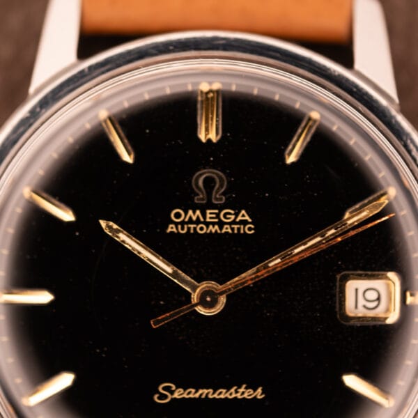 Omega Seamaster 166.002 factory black gilt dial macro with gold-tone Seamaster script and applied dart markers