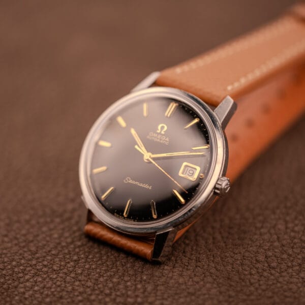 Omega Seamaster 166.002 full front view on tan grained leather strap against brown leather background