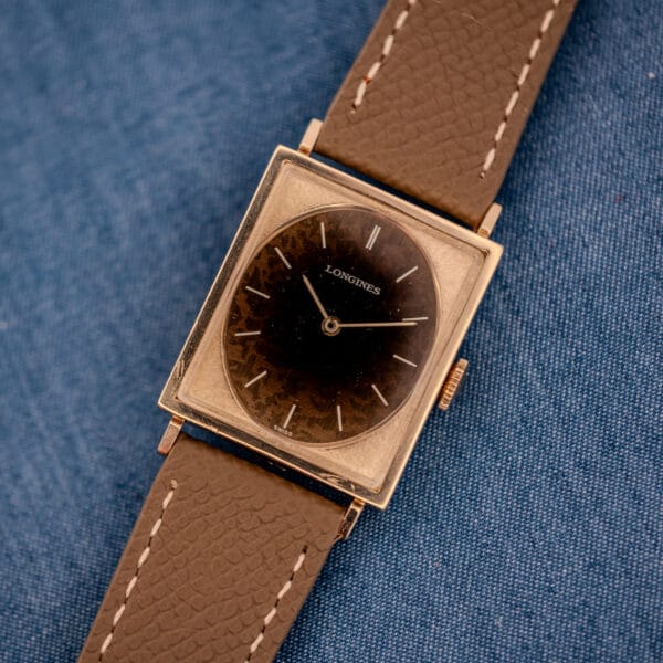 Longines Tank ref 3217-428 in 10k yellow gold filled, full square case with Leopard-patina dial on mud grey textured leather, denim backdrop