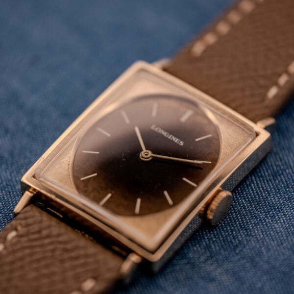 Macro of the Longines Tank 3217-428 Leopard dial with original slim baton hands and applied gold stick markers ringing the chocolate field