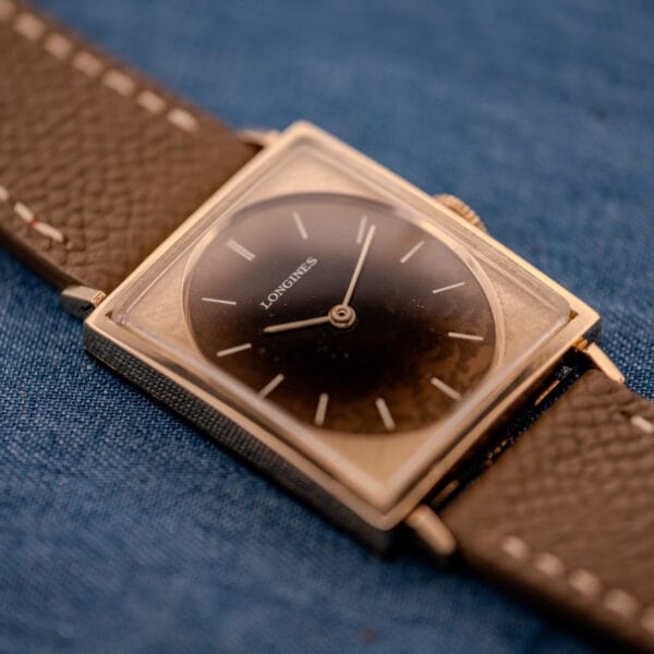 Wide angle on the Longines Tank ref 3217-428 with crown engaged, leopard-patinated dial reading clear under the acrylic crystal