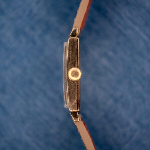 Macro of the right case side of the Longines Tank 3217-428 showing the period-correct signed crown and polished gold filled case band