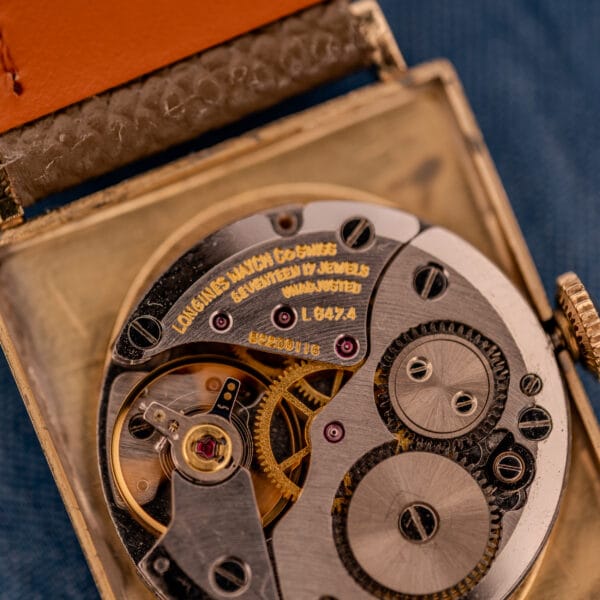 Macro engraving of the Longines L647.4 caliber reading LONGINES WATCH CO SWISS, SEVENTEEN 17 JEWELS UNADJUSTED, with the L647.4 designation in gold-toned text