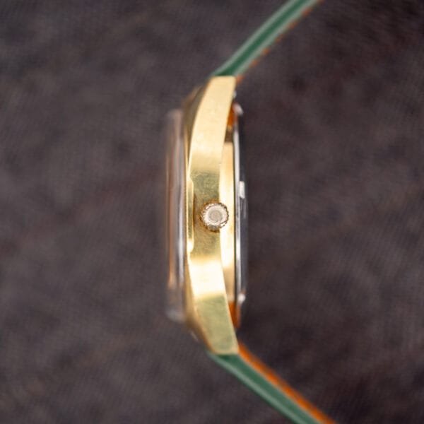 Right-side profile of the Omega Electronic F-300 Hz ref. 1980045 showing the period Omega-signed crown and gold-plated case slab