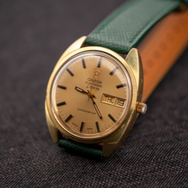 Hero shot of the Omega Electronic F-300 Hz Chronometer ref. 1980045 on a pine green saffiano leather strap