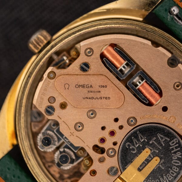 Macro of the Omega caliber 1260 cartouche reading OMEGA 1260 UNADJUSTED with serial 35652308 next to the twin copper electromagnetic coils