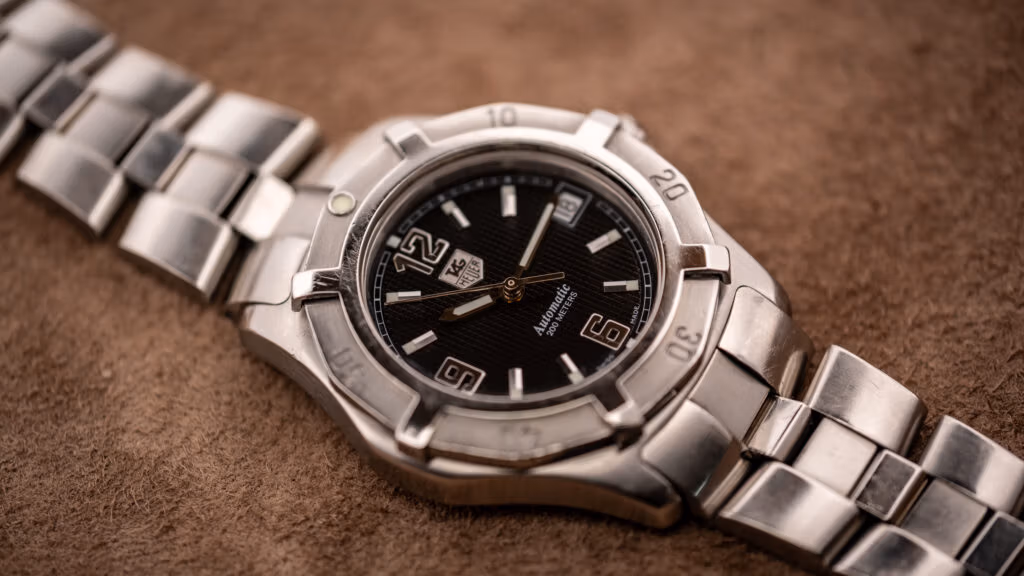Vintage TAG Heuer 2000 Series Professional Exclusive automatic with black waffle dial, applied numerals, and steel bracelet