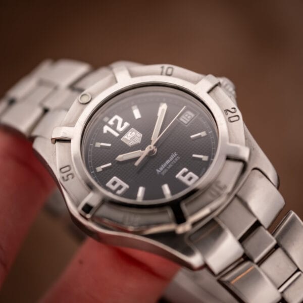 TAG Heuer WN2111 black waffle dial automatic diver tilted in hand showing dial texture