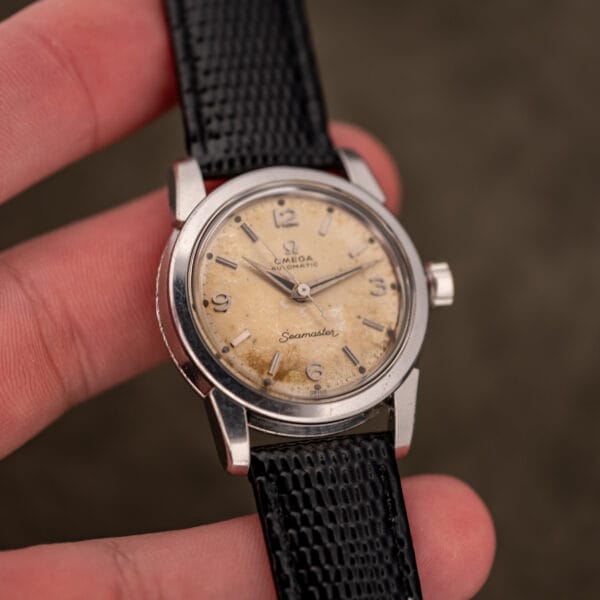 Omega Seamaster 2828 held in hand showing aged cream and chocolate tropical dial