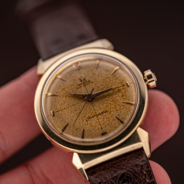 Omega Seamaster Ref. 14363-3 held in hand at angle, dial detail and faceted lugs visible
