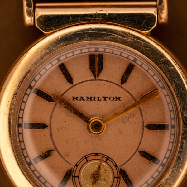 Hamilton Prescott factory salmon dial close-up with HAMILTON wordmark and gilt dauphine hands
